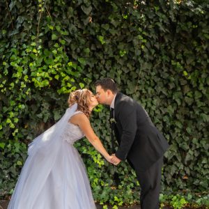 Bride and groom kissing in lush green setting | Forevermore Moments Bride and groom kissing in lush green setting | Forevermore Moments